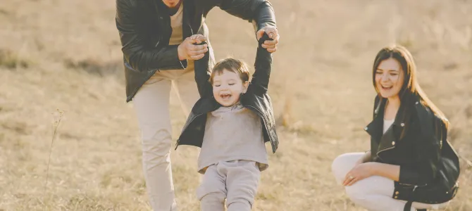 familia jugando con niño al aire libre