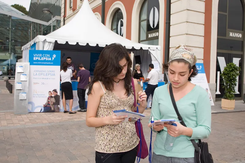 Dos jóvenes completan el cuestionario sobre epilepsia que se repartió en la carpa instalada en las inmediaciones del C.C. Príncipe Pío.